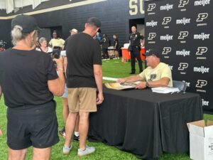Football Coach Barry Odem signing autographis for fans